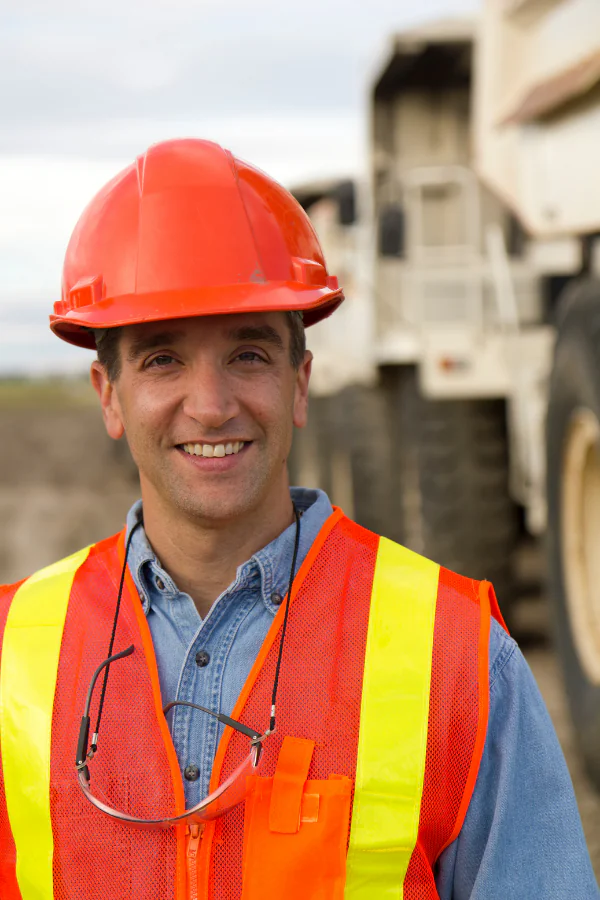 Industrial plant operator in hard hat and high-visibility vest at an outdoor worksite